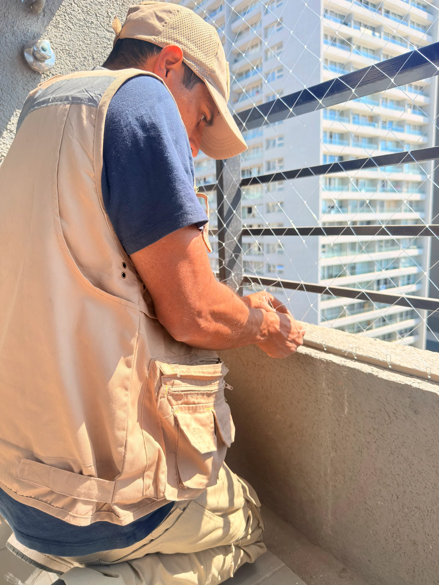 Instalador trabajando en los anclajes de una malla